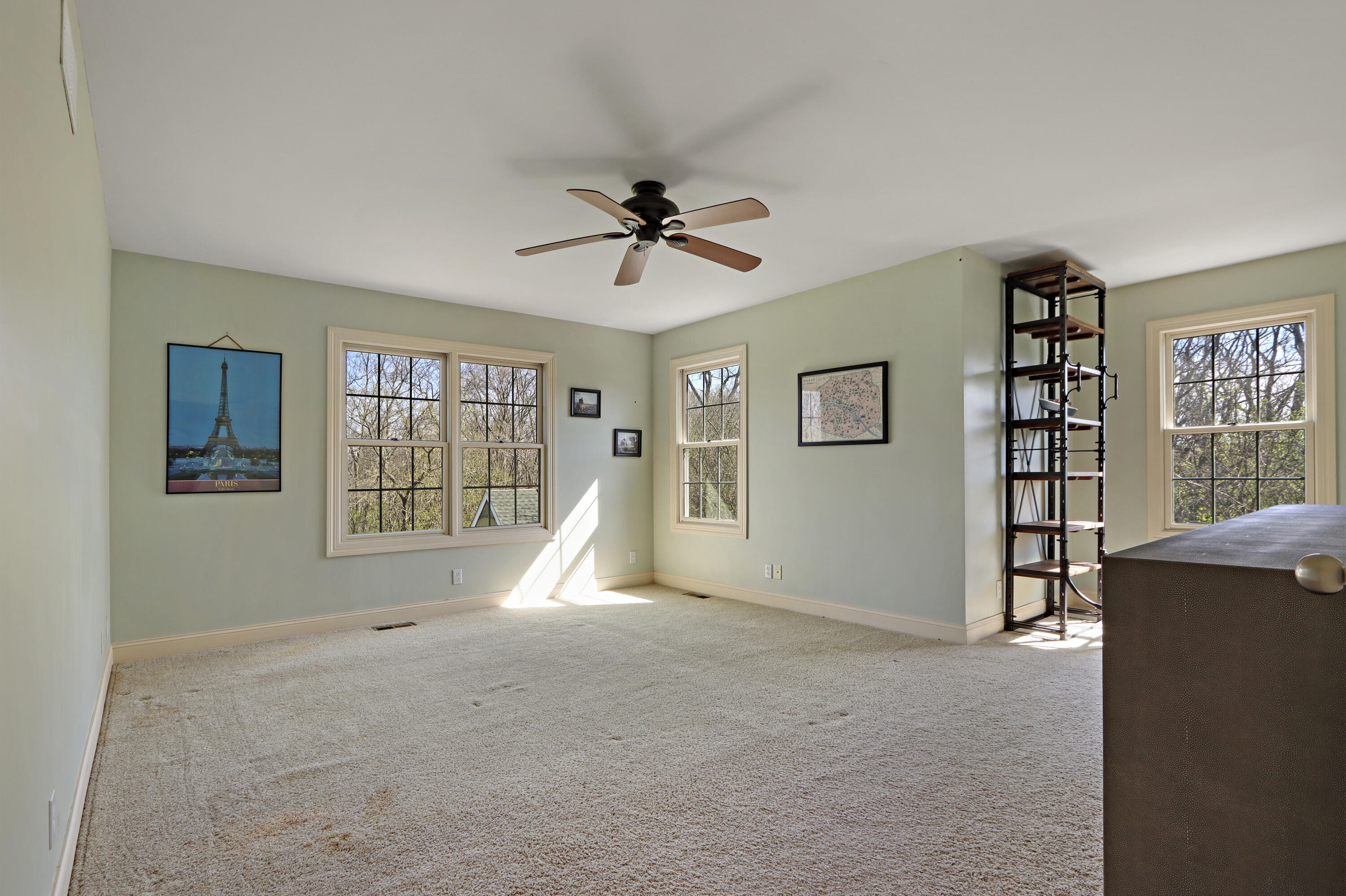 392 County Road B Fontana, WI 53125 - Photo 27 of 75 The sunny Primary Bedroom has beautiful views over the back yard of the ponds, woodlands and golf course and has an alcove for catching up on work or reading.