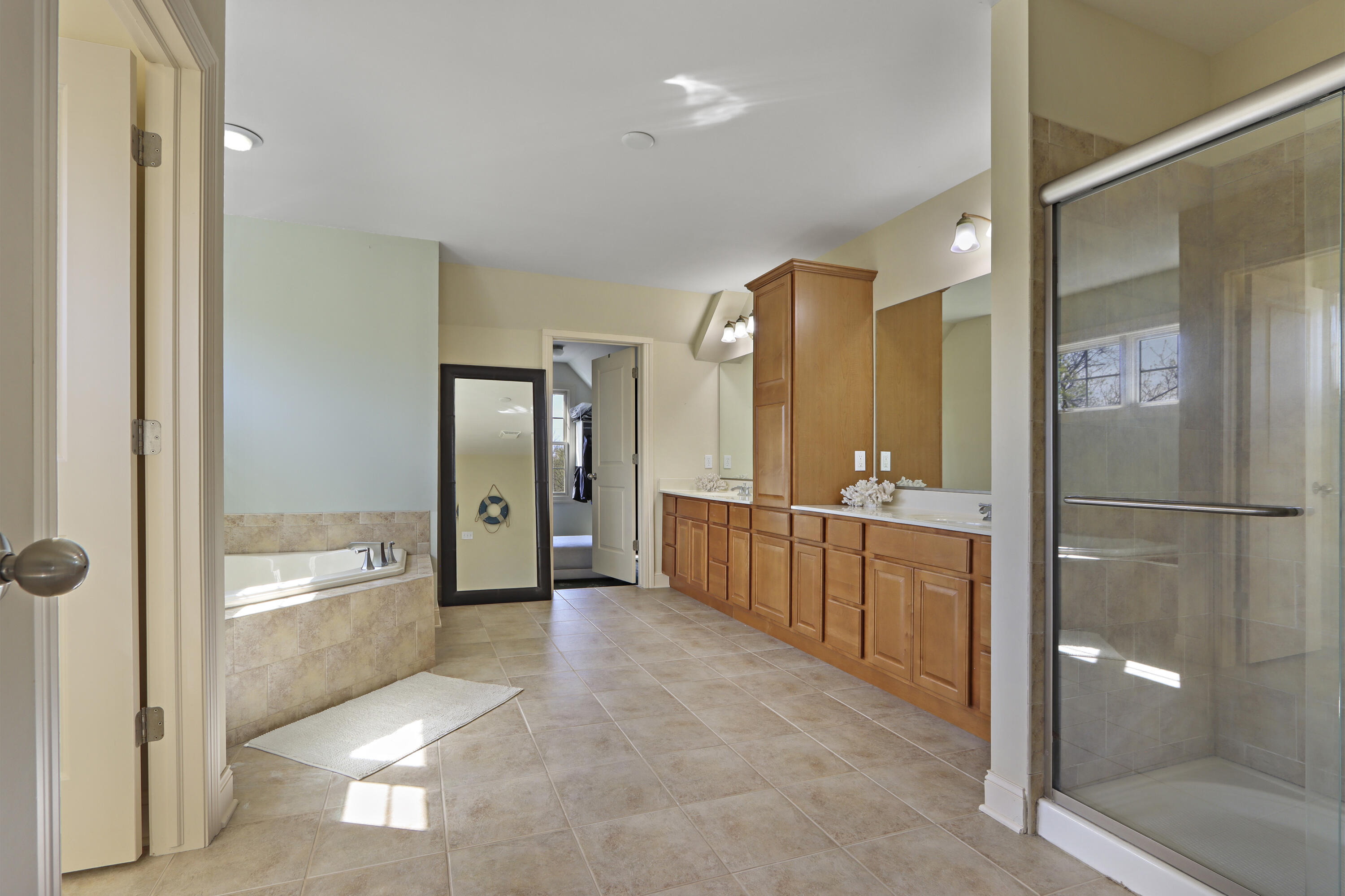 392 County Road B Fontana, WI 53125 - Photo 29 of 75 The huge Primary Suite bathroom has tile floors, a walk-in shower, jetted tub, private toilet area with window and a large, walk0in closet