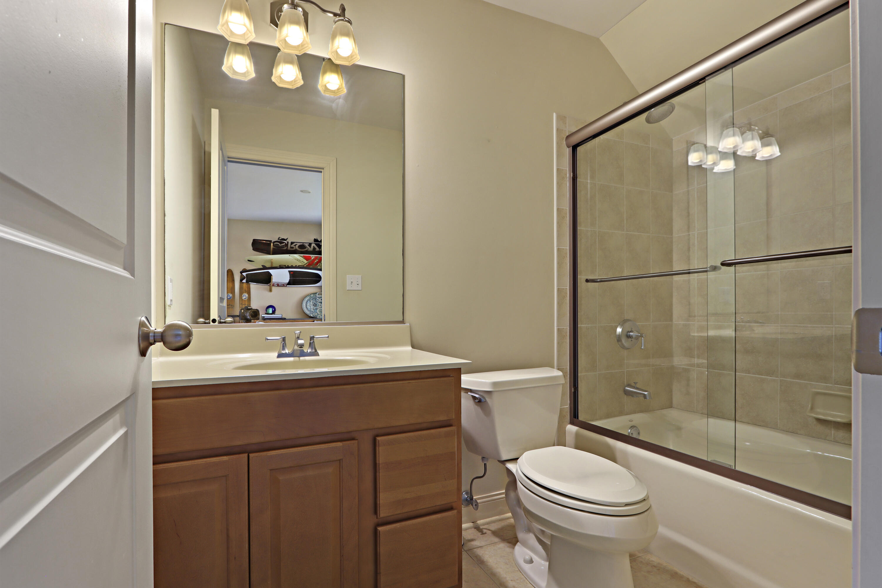 392 County Road B Fontana, WI 53125 - Photo 36 of 75 Bedroom 3 has a great ensuite bathroom with single sink vanity, tile floor, tub/shower with tile surround and glass door.