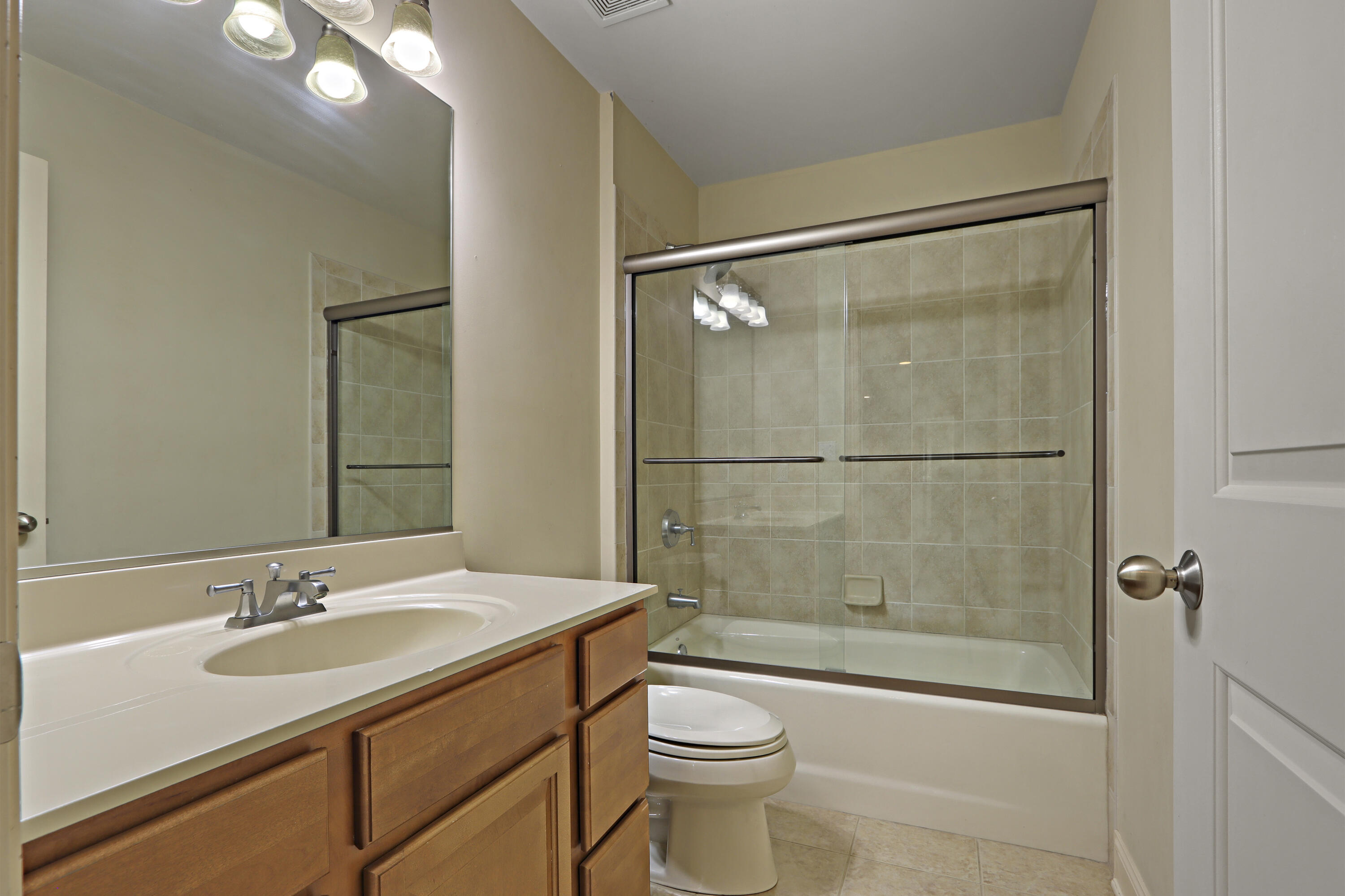 392 County Road B Fontana, WI 53125 - Photo 42 of 75 The UL Full Bathroom has a single sink vanity, tile floor, tub/shower with tile surround and glass shower door