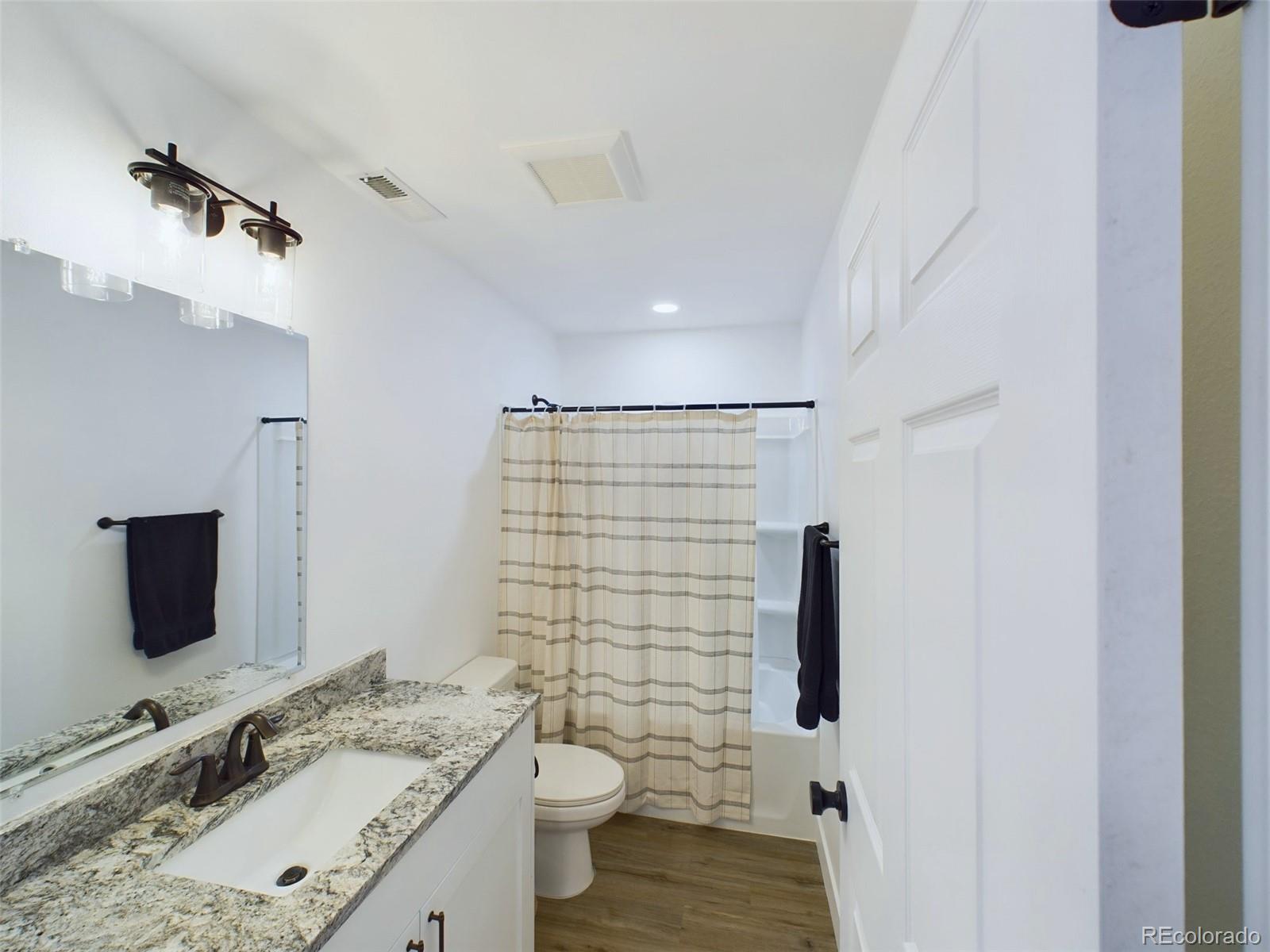 1439 Brewery Road Pueblo, CO 81001 - Photo 18 of 25 a bathroom with a granite countertop sink toilet and shower