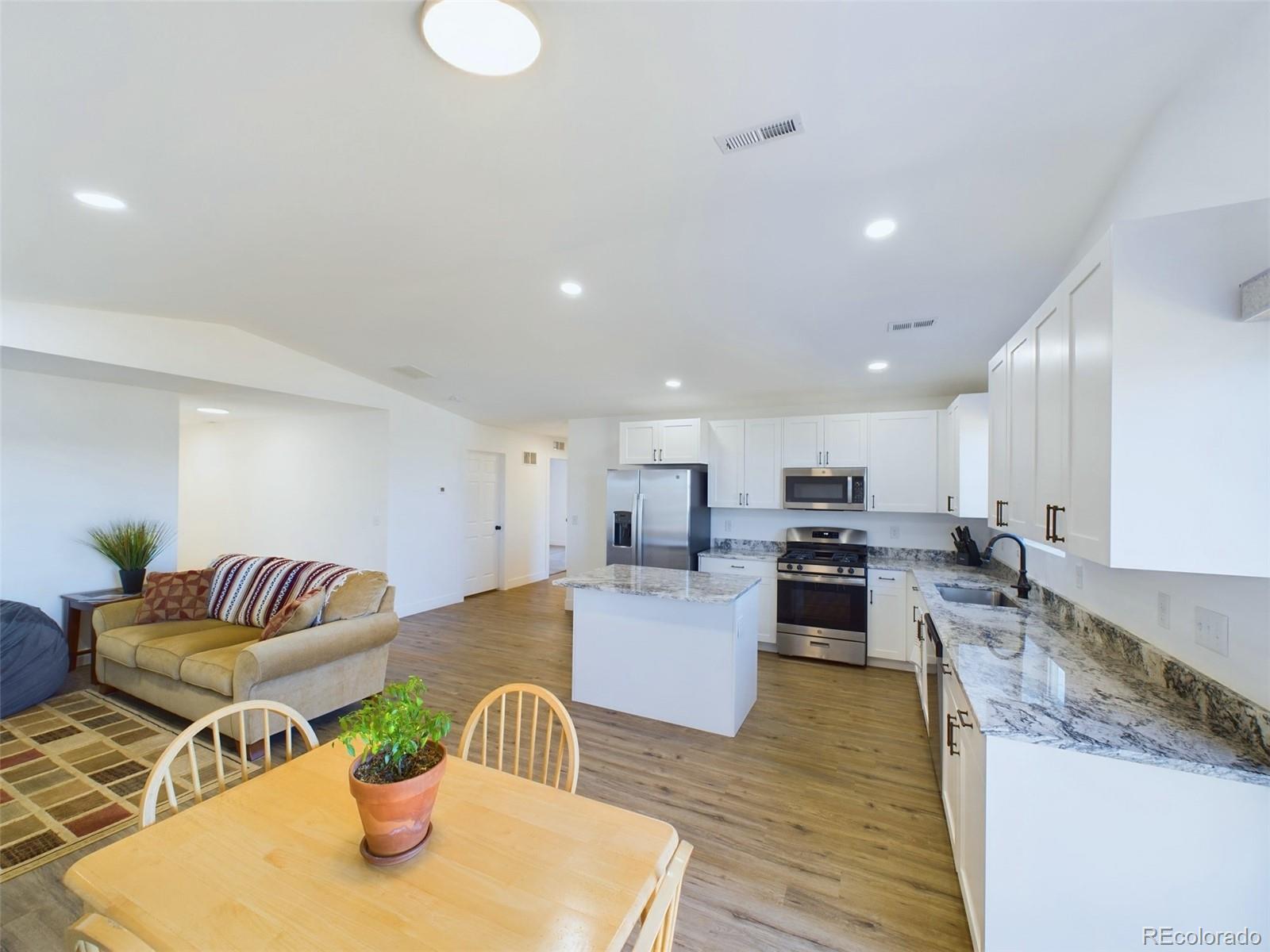 1439 Brewery Road Pueblo, CO 81001 - Photo 7 of 25 a living room with kitchen island furniture and a wooden floor