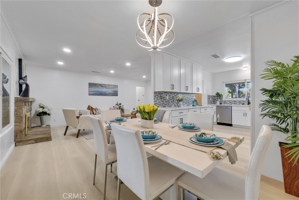a kitchen with a dining table chairs sink and white cabinets