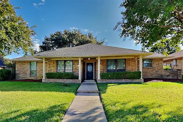 a front view of a house with yard and green space
