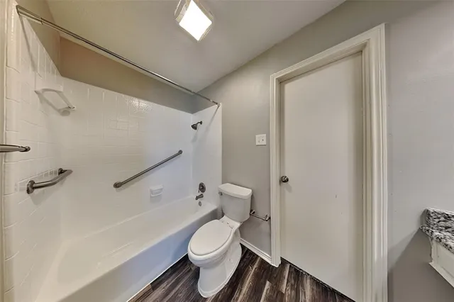 a white toilet sitting next to a bathroom sink and a shower