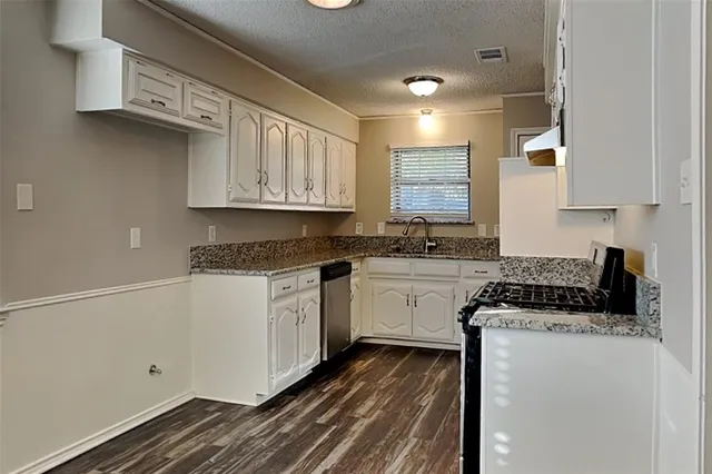 a kitchen with granite countertop white cabinets and white appliances