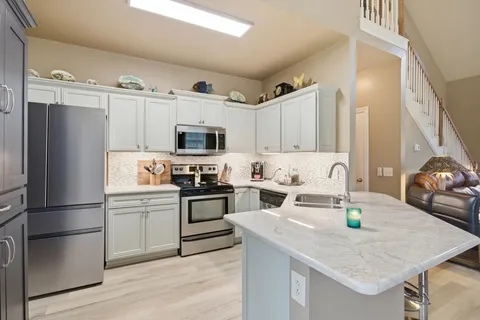 a kitchen with cabinets stainless steel appliances and a sink