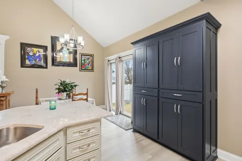 a kitchen with sink refrigerator dining table and chairs