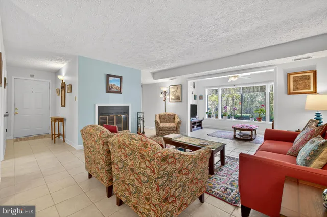 a living room with furniture large window and a fireplace