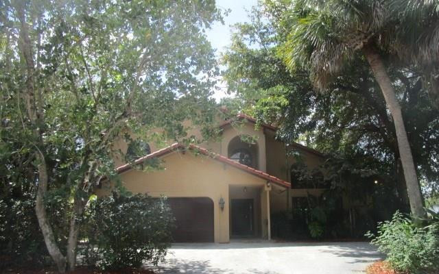 1498 Southwest 19th Street Boca Raton, FL 33486 - Photo 1 of 13 a house with trees in the background