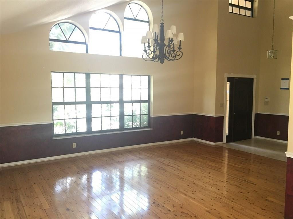 1498 Southwest 19th Street Boca Raton, FL 33486 - Photo 2 of 13 an empty room with wooden floor fan and windows
