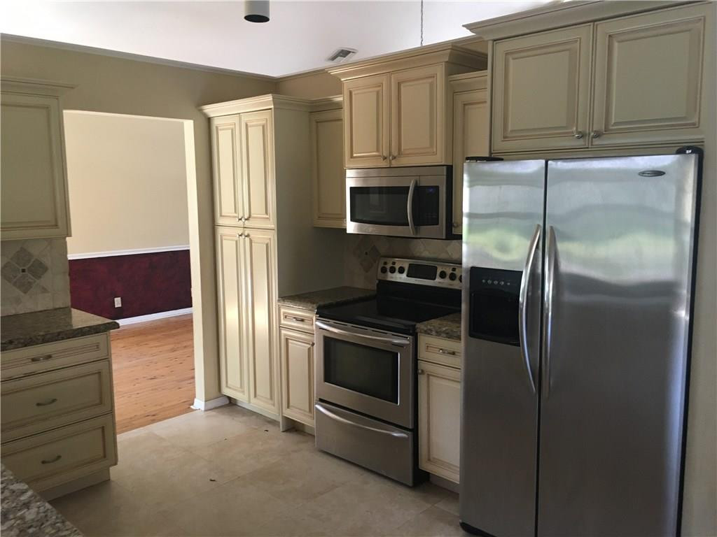 1498 Southwest 19th Street Boca Raton, FL 33486 - Photo 3 of 13 a kitchen with stainless steel appliances granite countertop a refrigerator and a stove
