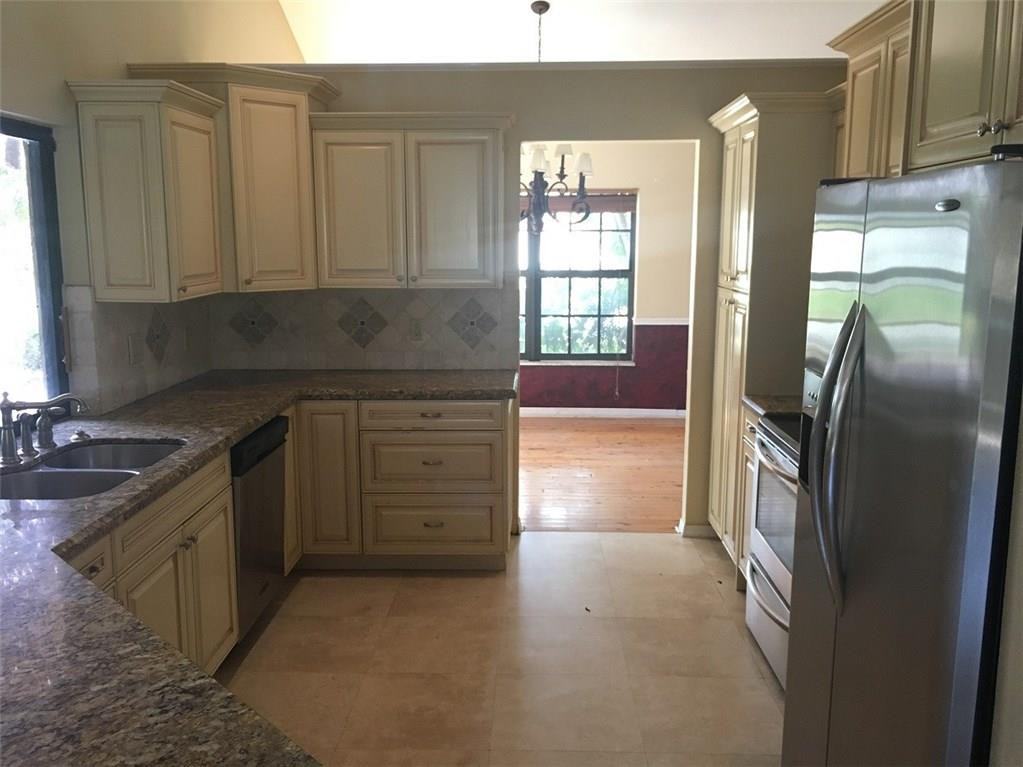 1498 Southwest 19th Street Boca Raton, FL 33486 - Photo 5 of 13 a kitchen with granite countertop a refrigerator and a sink
