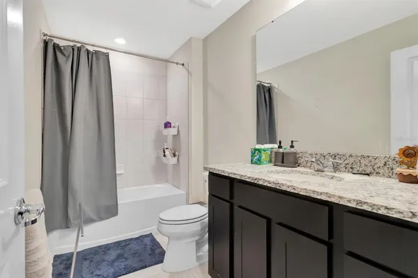 a bathroom with a granite countertop sink toilet and shower
