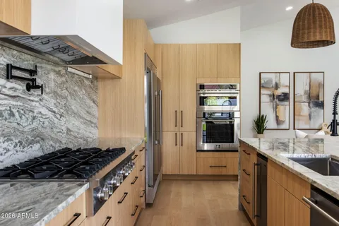 a kitchen with stainless steel appliances granite countertop a sink and a stove