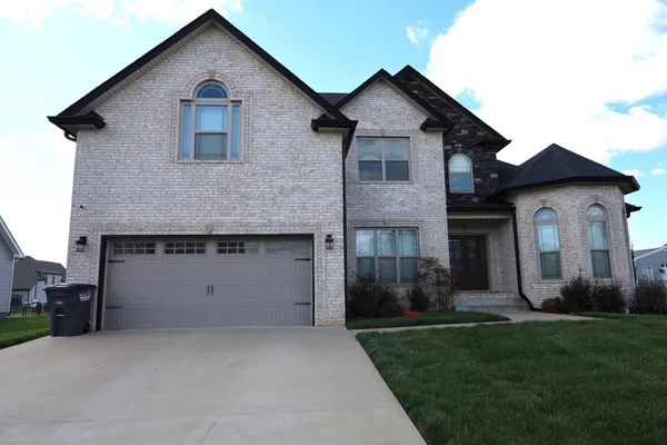 a front view of a house with a yard and garage