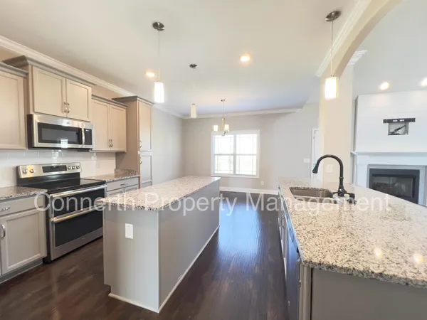a large kitchen with stainless steel appliances granite countertop a lot of counter space and wooden floors