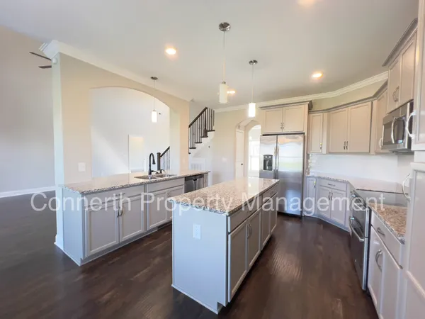 a kitchen with stainless steel appliances granite countertop a lot of counter space and wooden floors