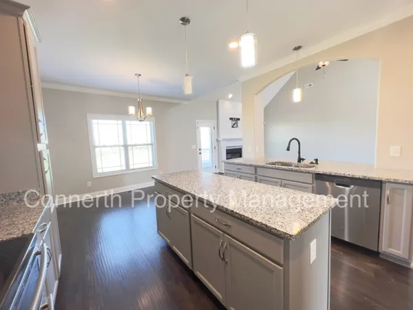 a kitchen with granite countertop a sink and a wooden floor