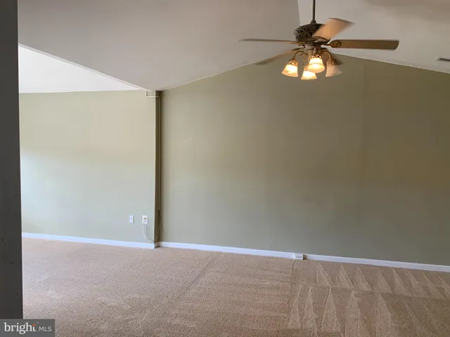 an empty room with a chandelier fan and a chandelier fan