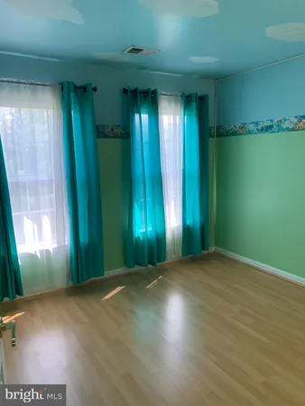 an empty room with closet and windows