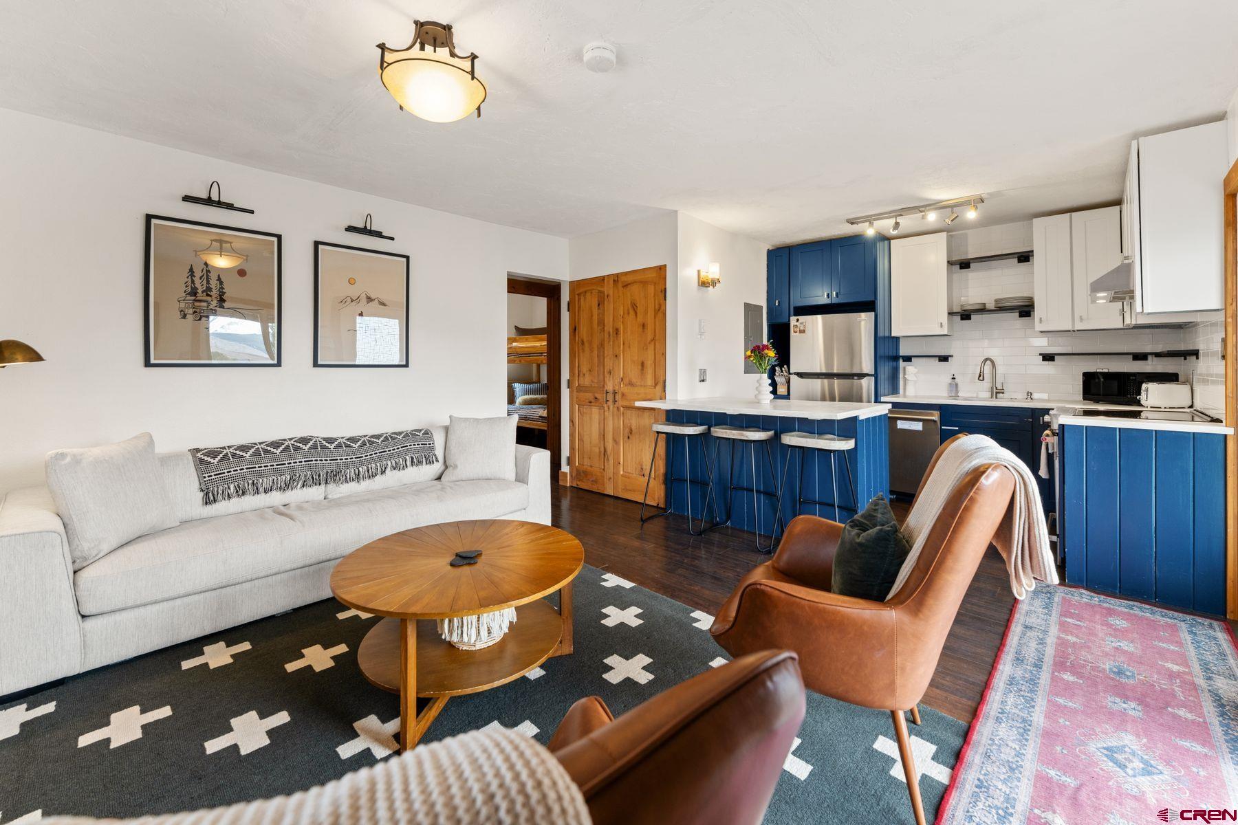 a living room with furniture a rug and a chandelier