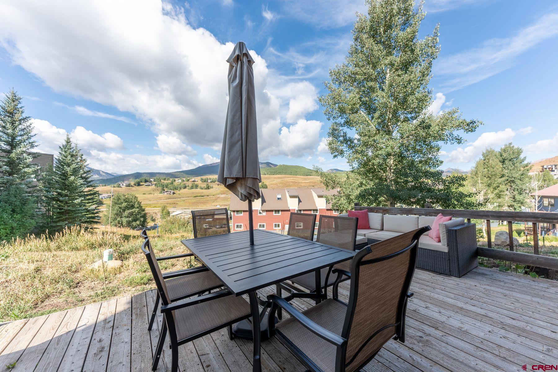 31 Castle Road, Unit 1 Crested Butte, CO 81225 - Photo 23 of 34 a view of a roof deck with table and chairs with wooden floor and fence
