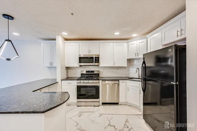 a kitchen with stainless steel appliances granite countertop a stove a refrigerator and a sink