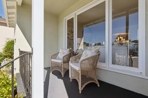 a view of balcony with two chairs and a potted plant