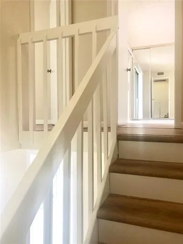 a view of staircase with wooden floor and white walls