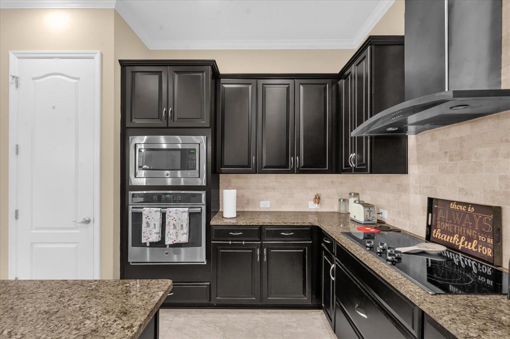 1547 Resolute Street Celebration, FL 34747 - Photo 11 of 40 a kitchen with stainless steel appliances granite countertop a refrigerator and a stove top oven