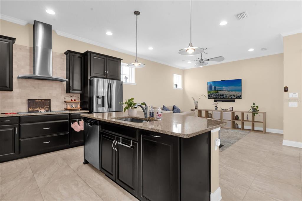 1547 Resolute Street Celebration, FL 34747 - Photo 12 of 40 a kitchen with stainless steel appliances kitchen island granite countertop a sink a stove a refrigerator and chairs