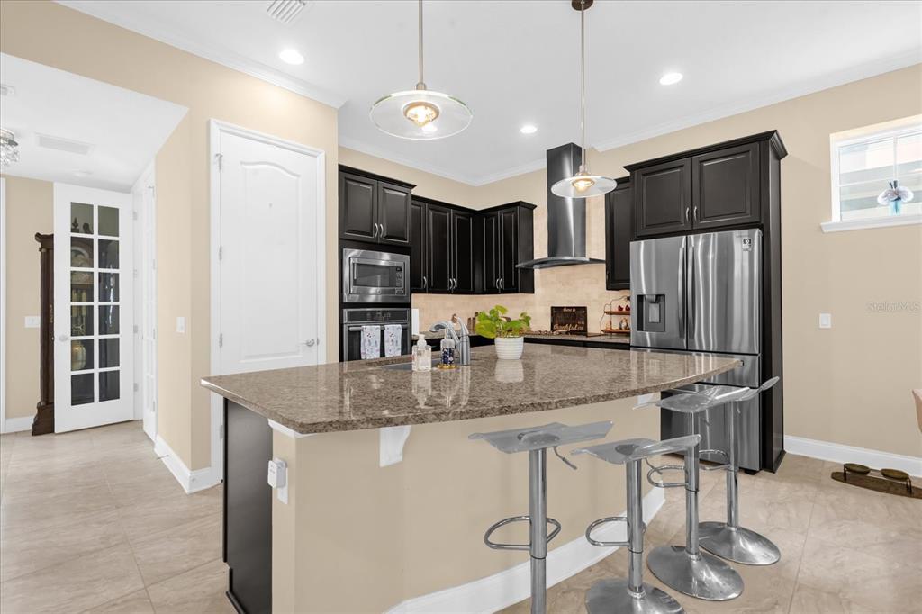 1547 Resolute Street Celebration, FL 34747 - Photo 13 of 40 a kitchen with stainless steel appliances granite countertop a sink refrigerator and cabinets