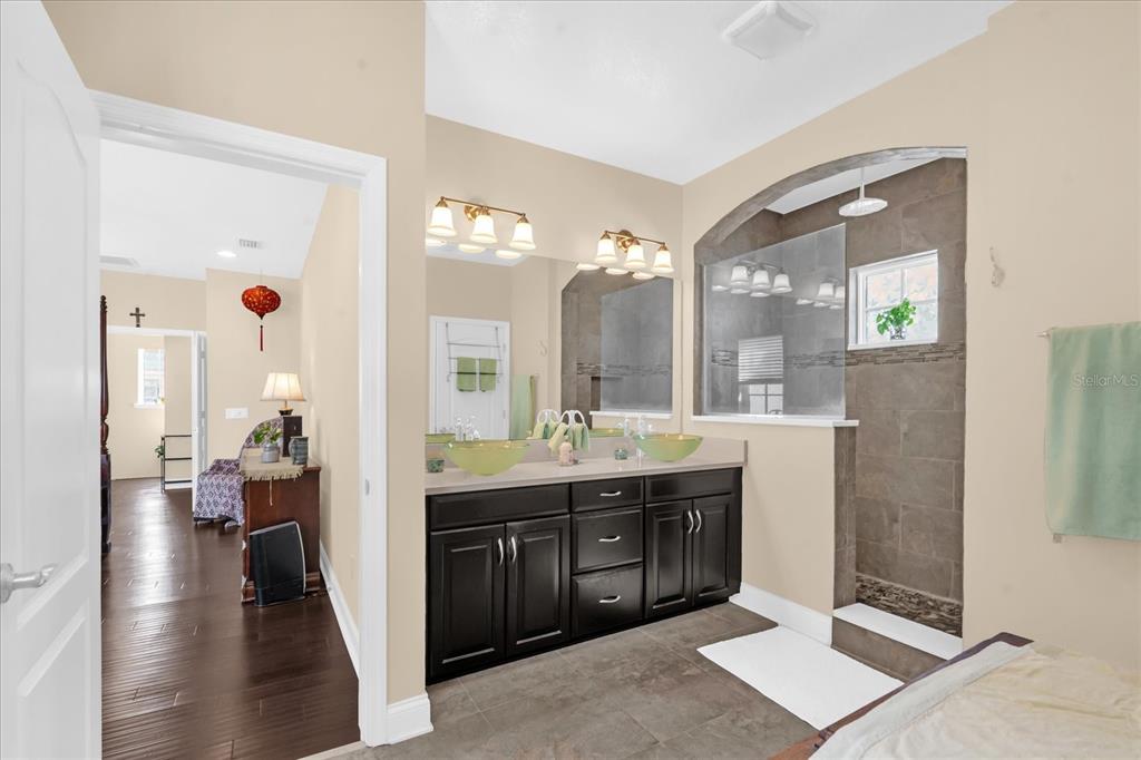 1547 Resolute Street Celebration, FL 34747 - Photo 18 of 40 a spacious bathroom with a granite countertop sink a mirror and a shower