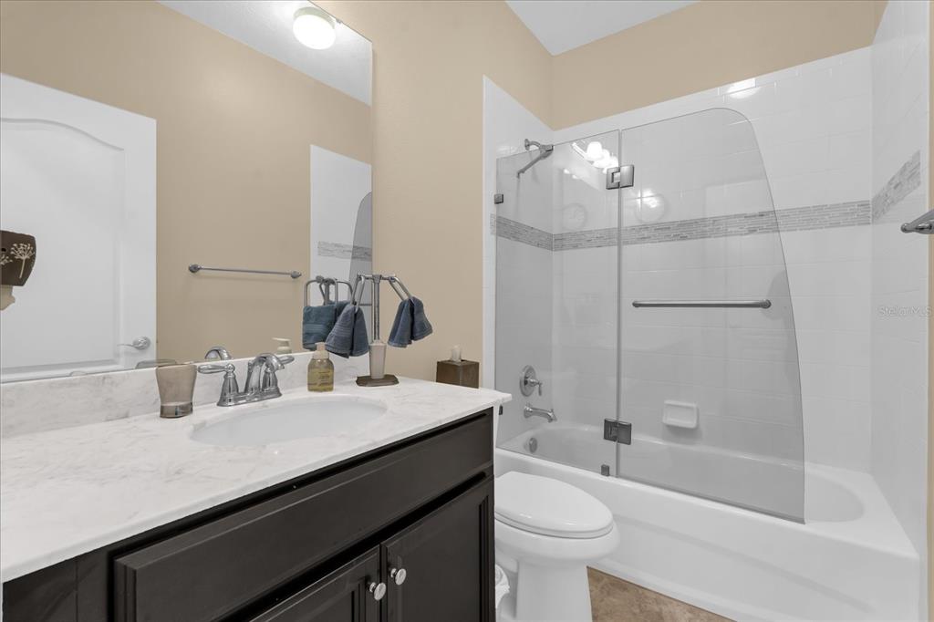1547 Resolute Street Celebration, FL 34747 - Photo 23 of 40 a bathroom with a double vanity sink toilet and shower