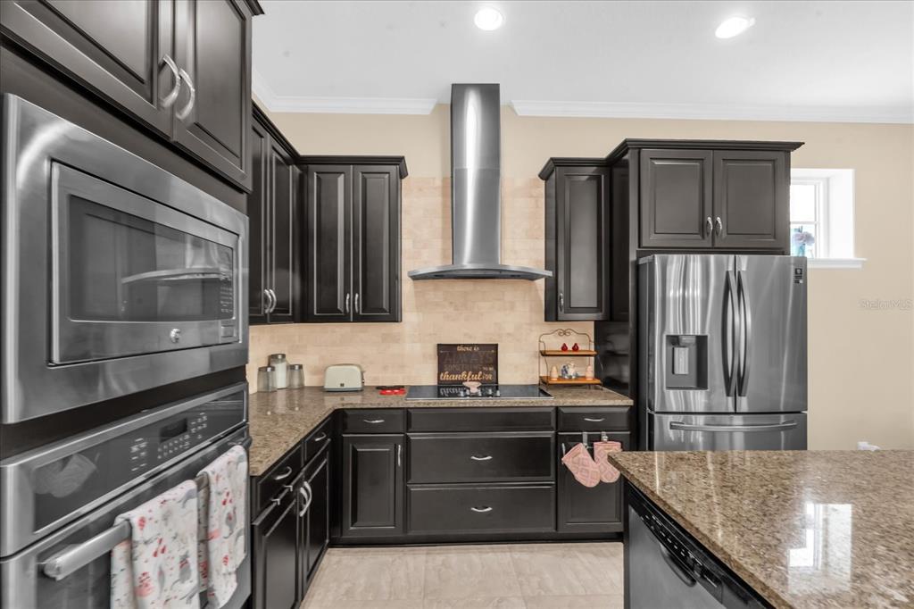 1547 Resolute Street Celebration, FL 34747 - Photo 10 of 40 a kitchen with stainless steel appliances granite countertop a refrigerator and a stove