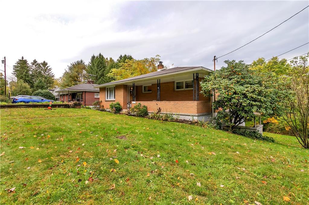 156 Wendel Road Herminie, PA 15637 - Photo 7 of 25 a front view of house with yard and trees in the background