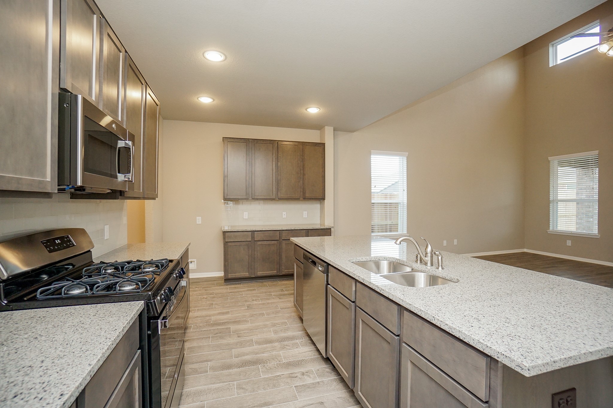 5463 Grand View Drive Fulshear, TX 77423 - Photo 9 of 32 a kitchen with stainless steel appliances granite countertop a sink stove and cabinets