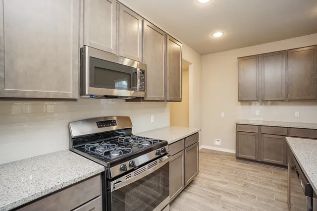 a kitchen with stainless steel appliances granite countertop a stove and a microwave