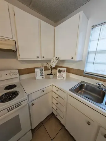 a kitchen with white cabinets and white appliances