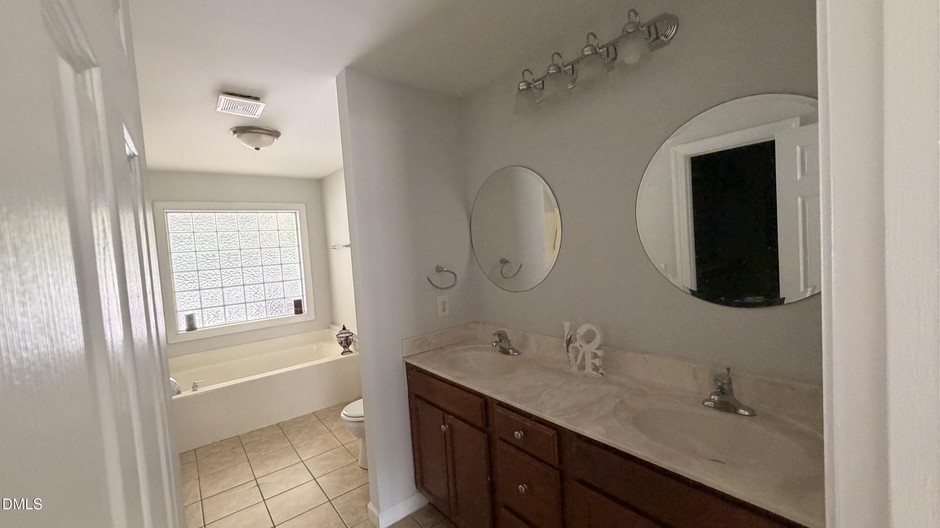 229 Sterling Way Angier, NC 27501 - Photo 7 of 10 a spacious bathroom with a double vanity sink a mirror and a bathtub