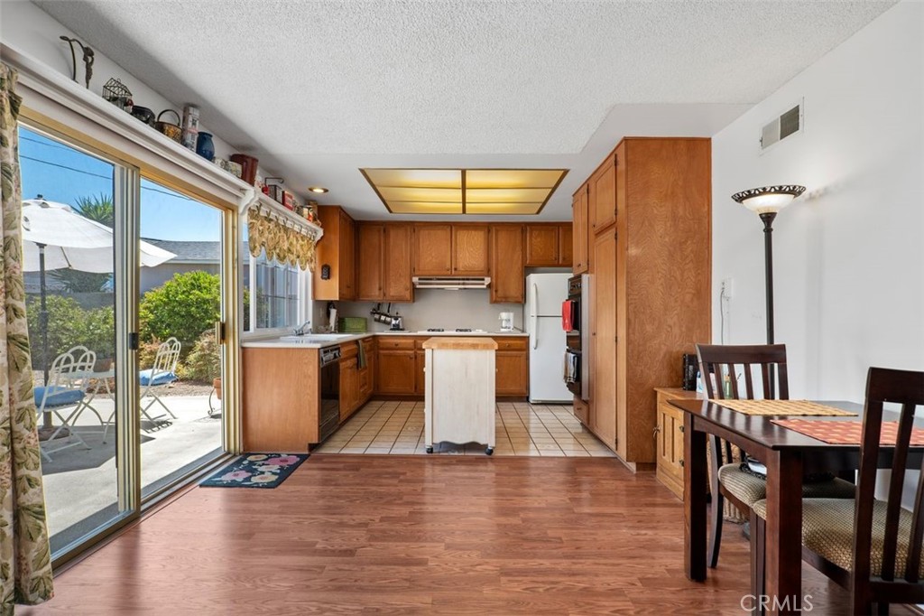 2233 East Everett Place Orange, CA 92867 - Photo 17 of 40 a kitchen with stainless steel appliances a dining table chairs and a large window