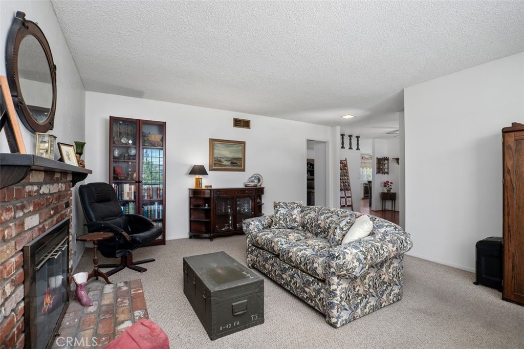 2233 East Everett Place Orange, CA 92867 - Photo 9 of 40 a living room with furniture a fireplace and a flat screen tv
