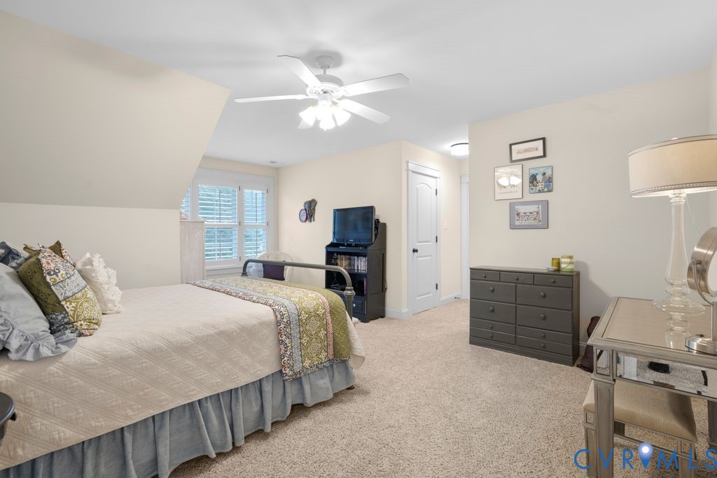 11518 Barrows Ridge Lane Chesterfield, VA 23838 - Photo 30 of 41 a spacious bedroom with a bed and a chandelier