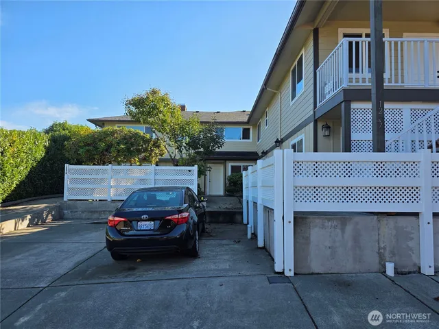 a view of a house with large windows and plants