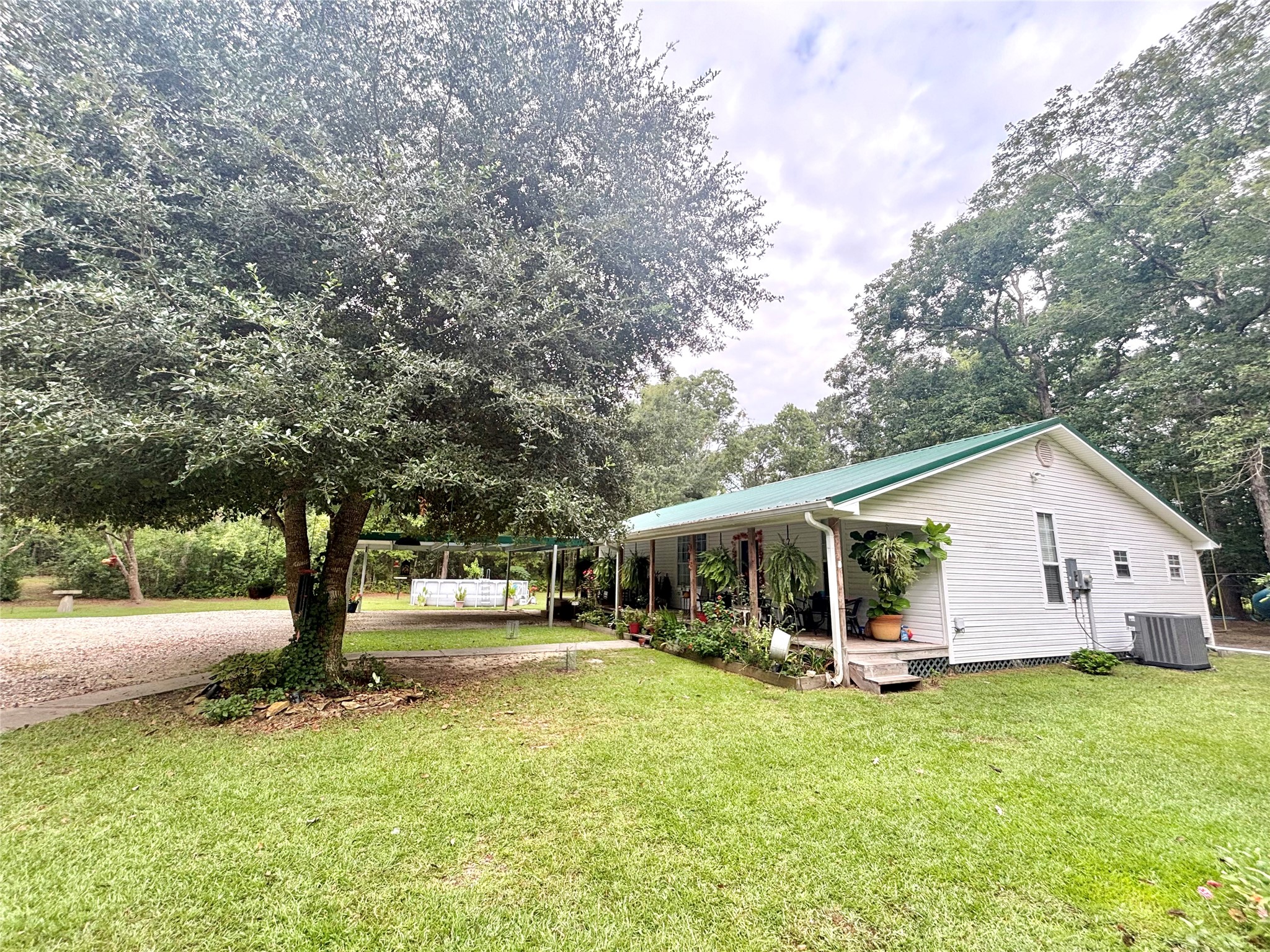 516 County Road 4800 Warren, TX 77664 - Photo 7 of 50 a view of a white house with a big yard and large trees