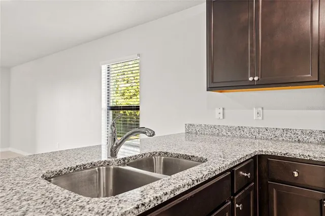 a large kitchen with a large counter top stainless steel appliances and cabinets