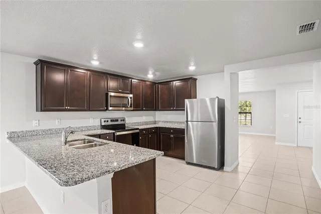 an empty room with a chandelier fan and windows