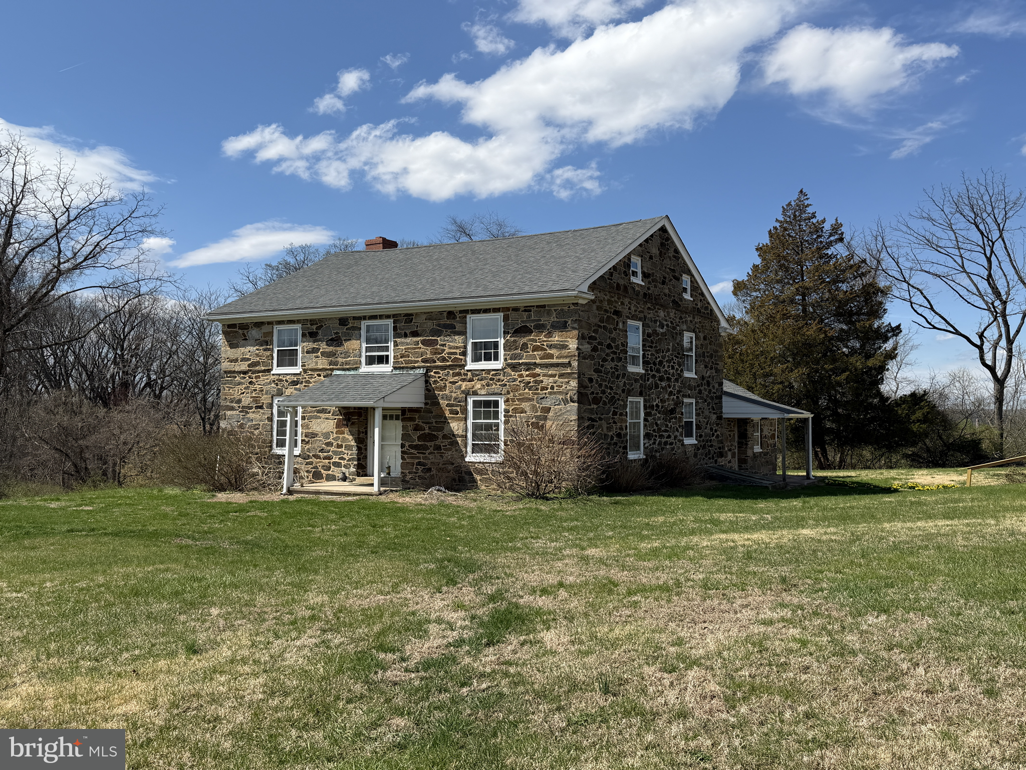 a view of a house with a big yard and large trees
