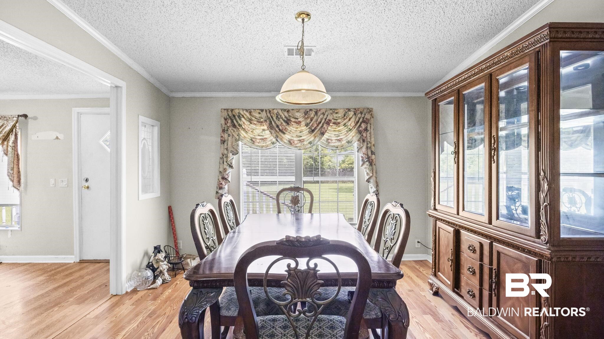 34985b Spring Road South, Unit B Stapleton, AL 36578 - Photo 13 of 31 Spacious room featuring wood-finish flooring, a large window with exterior visibility, a central ceiling light fixture, and a wide doorway opening